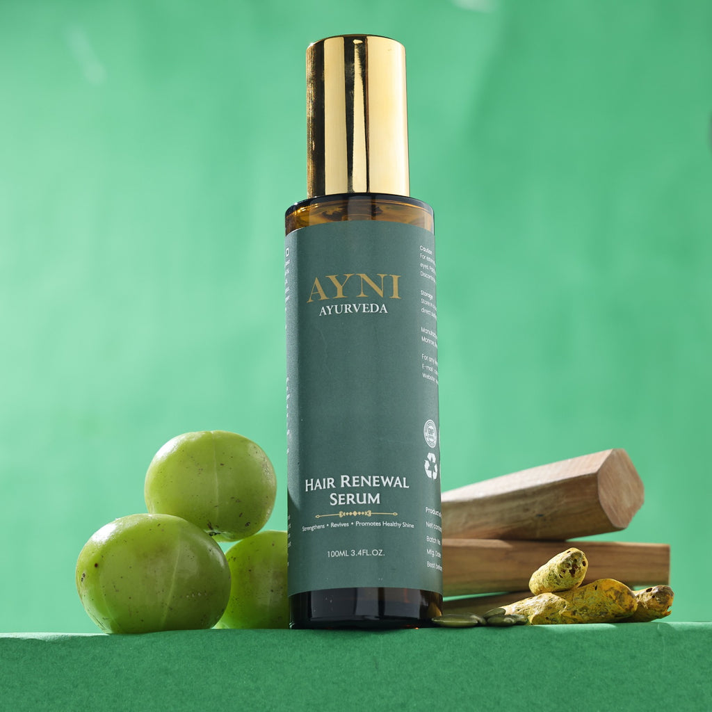 AYNI Ayurveda Hair Renewal Serum bottle with green apples and wooden elements on a green background