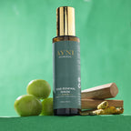 Ayni Ayurveda Hair Renewal Serum bottle with green apples and wooden elements on a green background