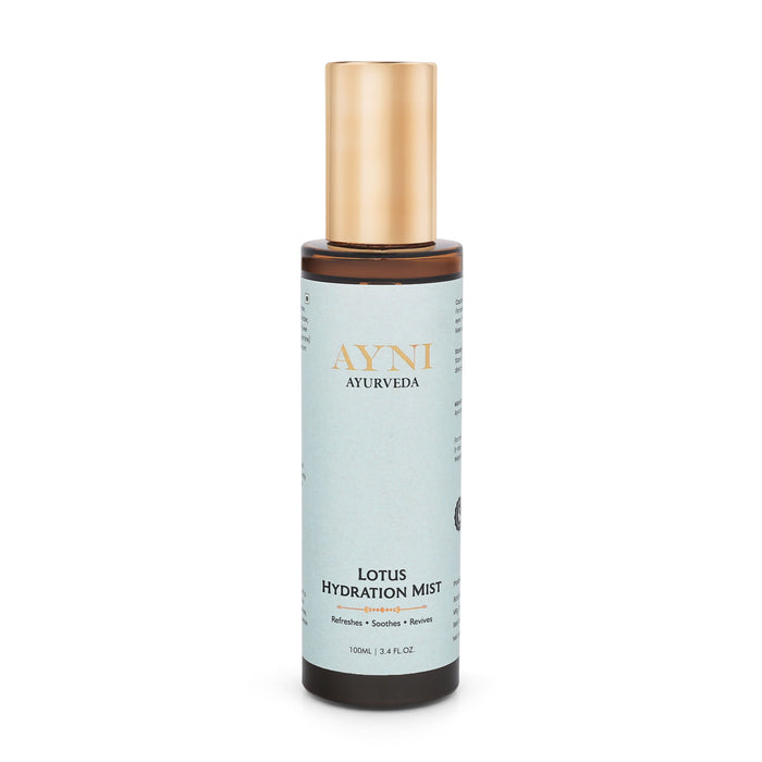 A bottle of Ayni Ayurveda Lotus Hydration Mist on a solid white background. The bottle has a light blue label with gold lettering, a dark brown base, and a metallic gold cap.