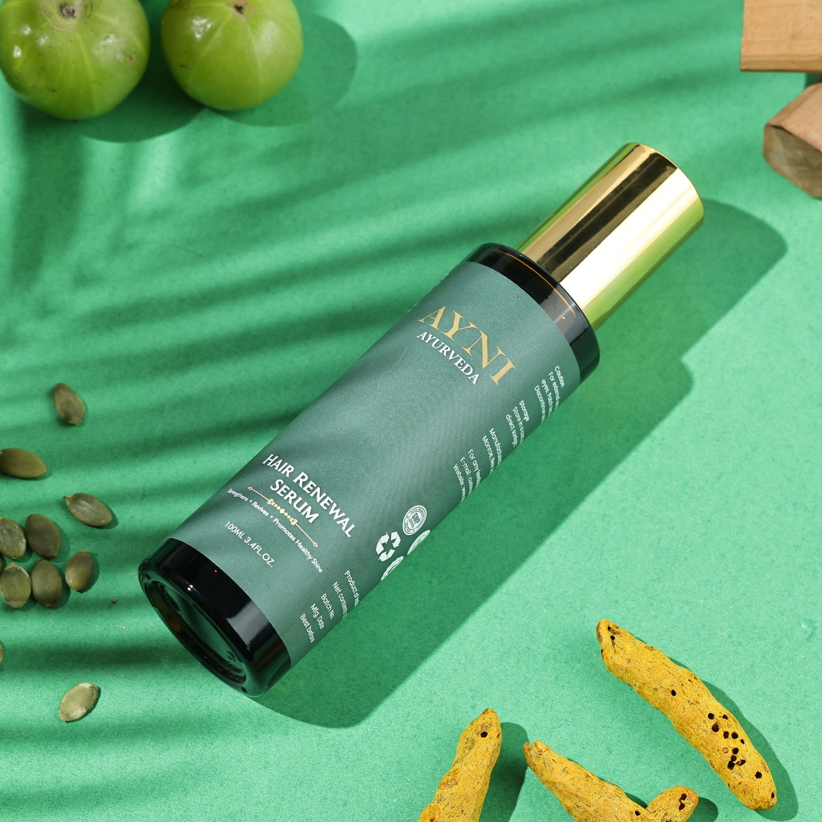 Hair renewal serum bottle on a green background with natural elements