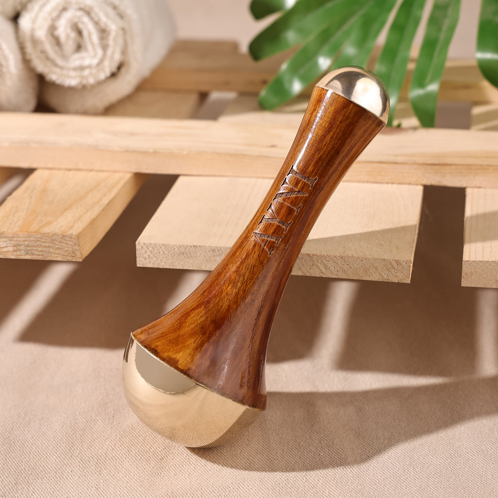 Wooden and metallic tool on a wooden surface with towels and greenery in the background
