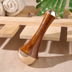 Wooden and metallic tool on a wooden surface with towels and greenery in the background