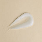 White cream droplet on beige background