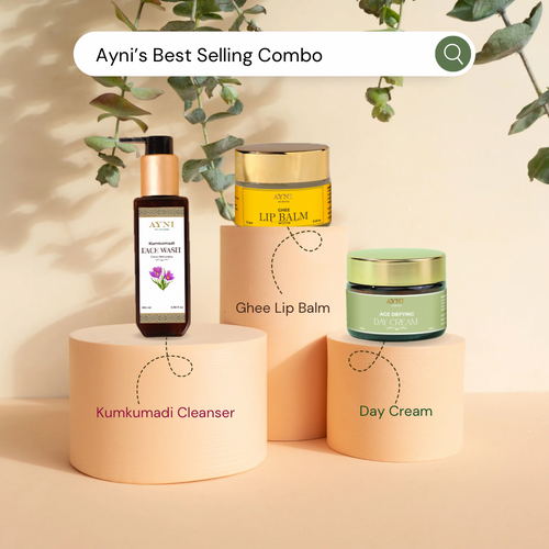 Ayni skincare products including Kumkumadi Cleanser, Ghee Lip Balm, and Day Cream on a beige background with greenery.