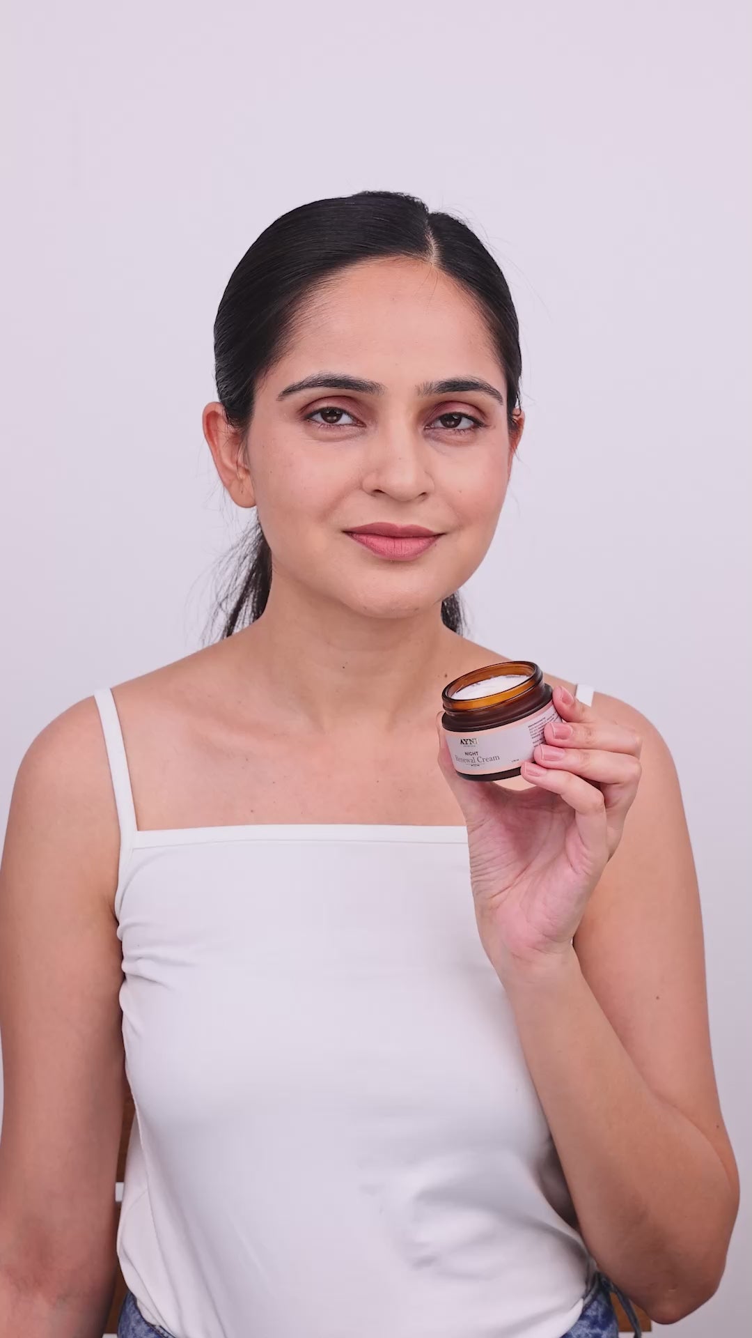 A lady showing how to apply night renewal  cream