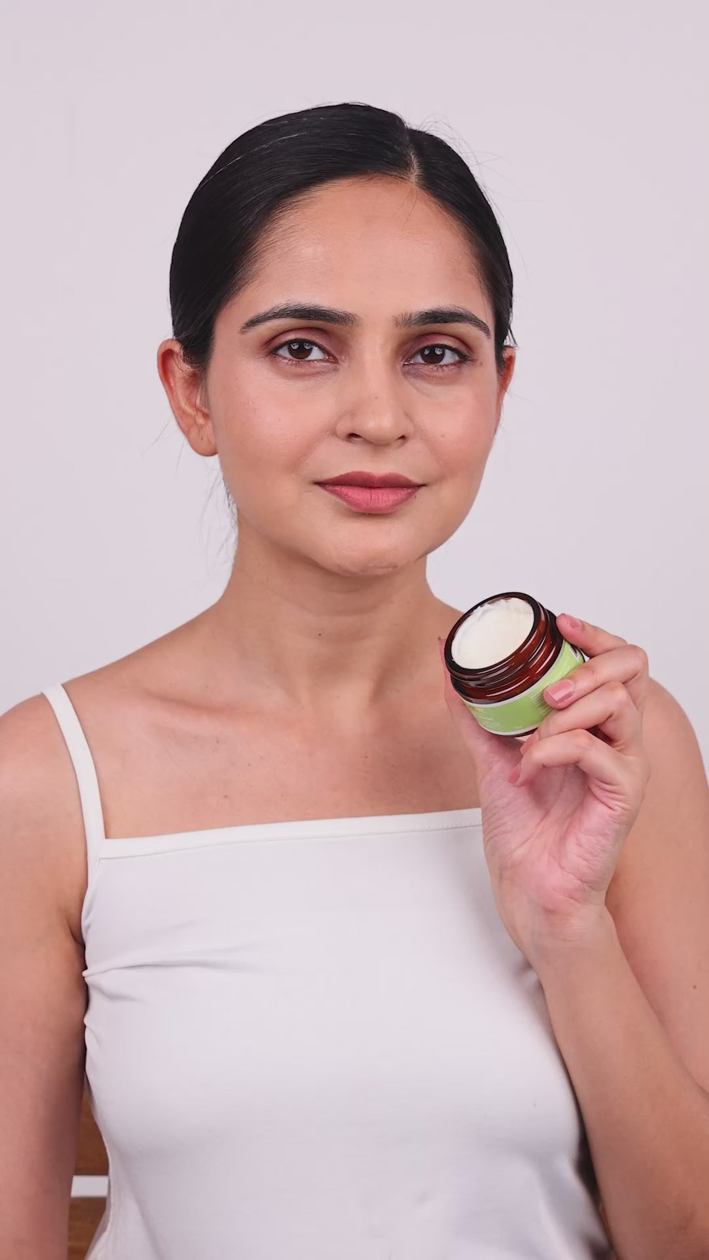 A lady showing how to apply age defying day cream
