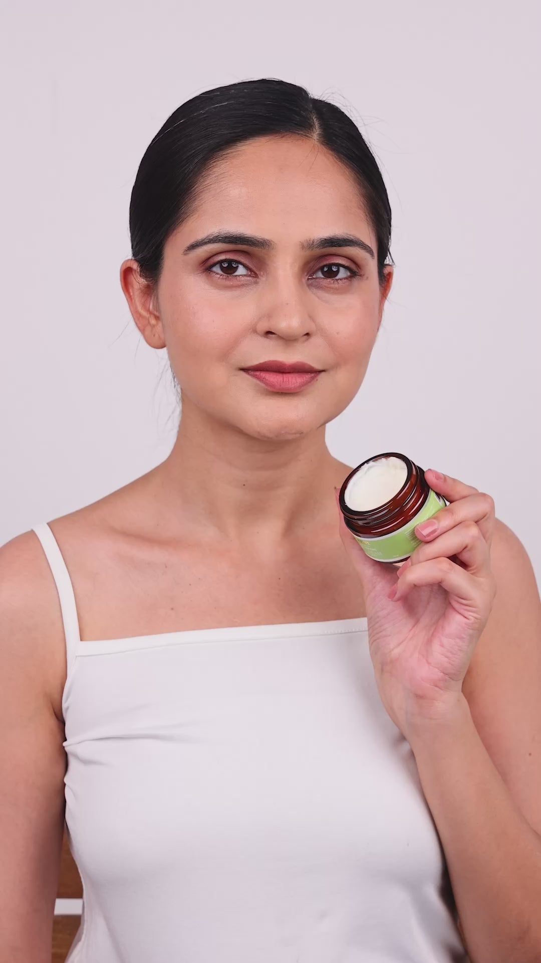 A lady showing how to apply age defying day cream
