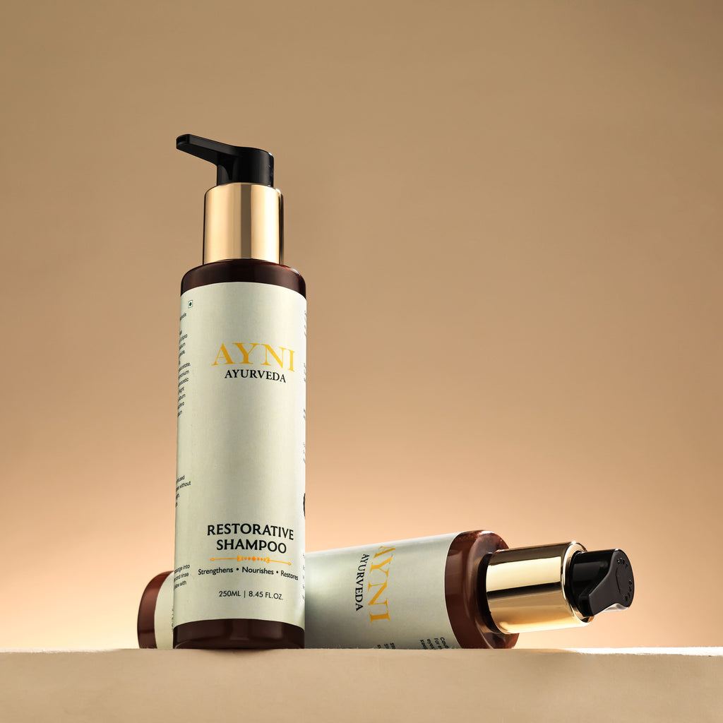 two bottles of ayni ayurveda restorative shampoo